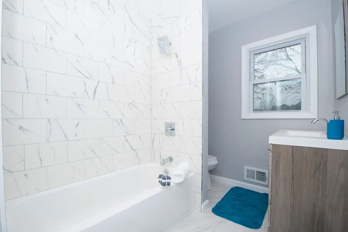 Small bathroom with marble tiled bathtub