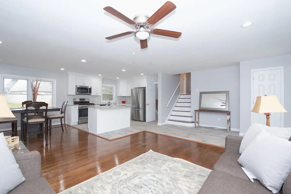 Open space with living room, dining room, and kitchen with ceiling fan
