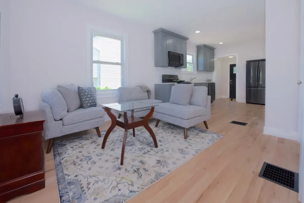 Living room with three gray upholstered chairs and a large patterned rug