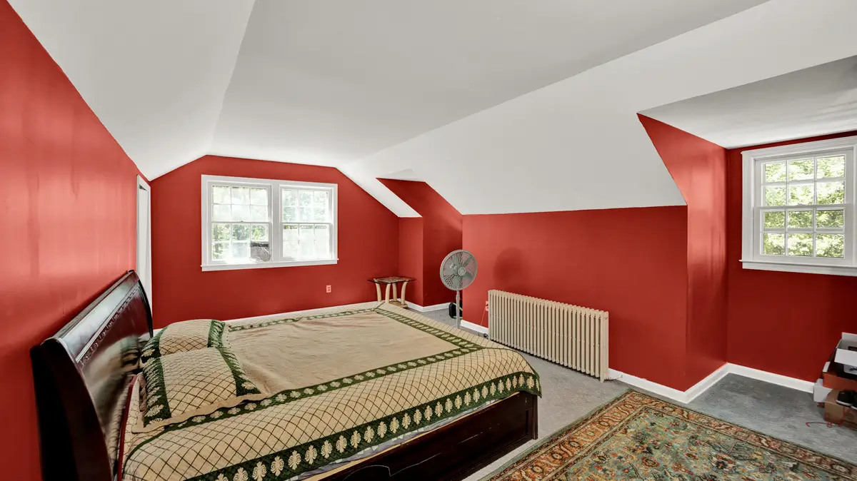 Spacious room with double bed and red walls