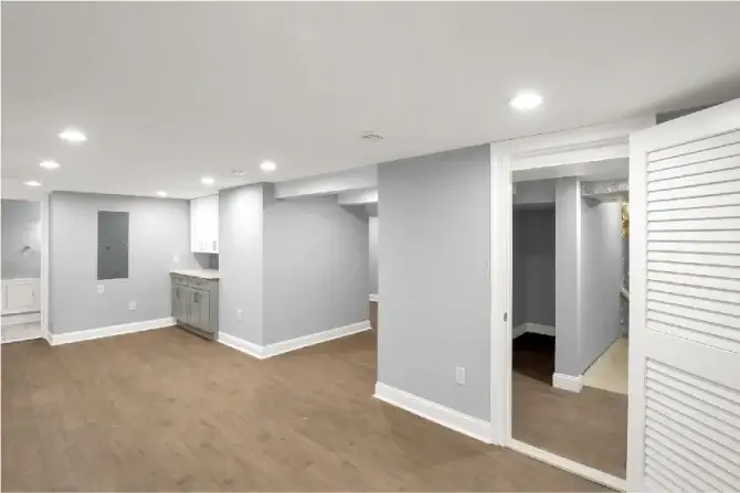 Renovated basement with gray walls and wood-like flooring