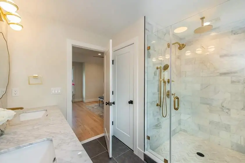 Modern bathroom with marble shower and double golden showerheads