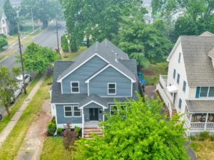 Aerial view of a two-story blue house with a dark gray roof