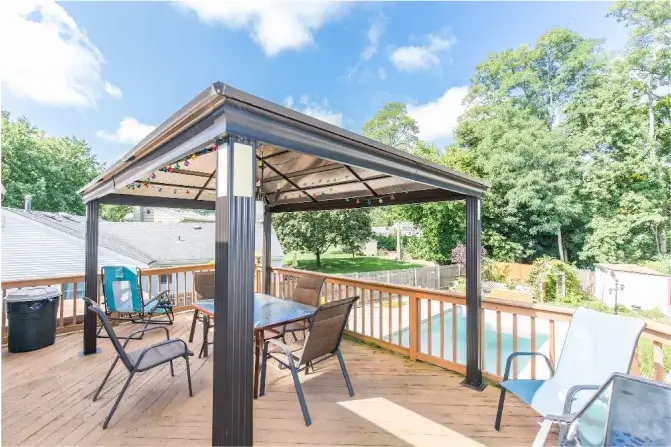 Outdoor terrace area with a metal structure gazebo and a roof.